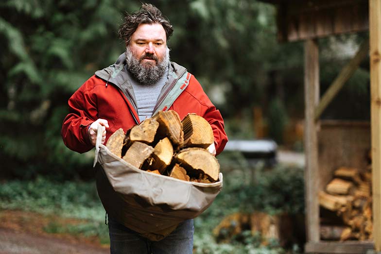 Toby Hargrave carrying firewood outdoors